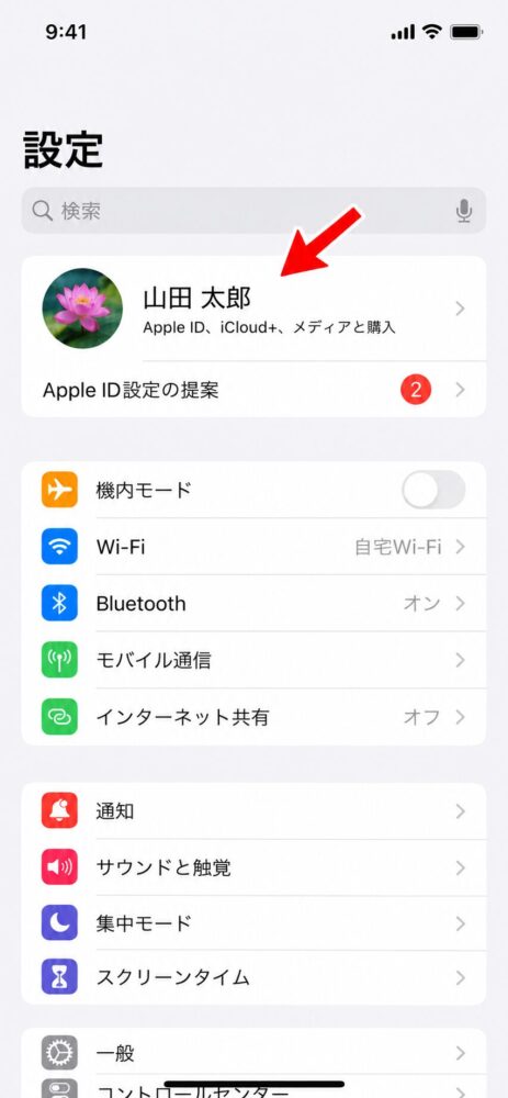 設定画面の一番上に表示された、自分の名前とApple IDを指し示している画像